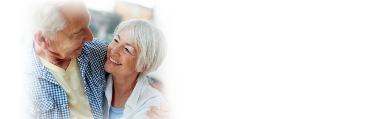 Elderly couple hugging and smiling