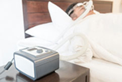 Patient in bed with CPAP mask